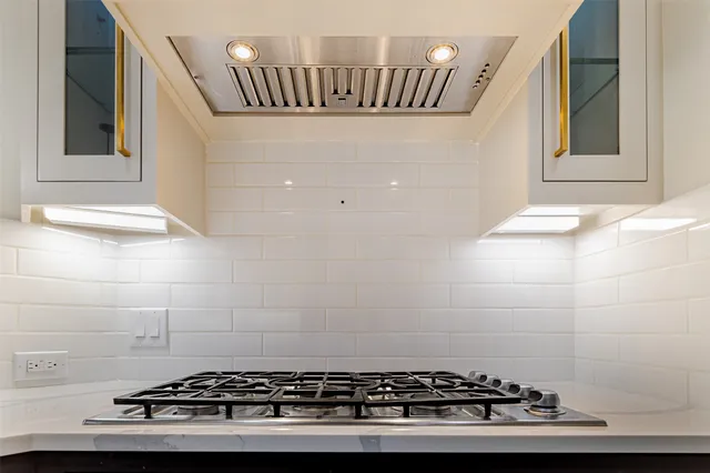 an empty room with wooden floor chandelier and windows