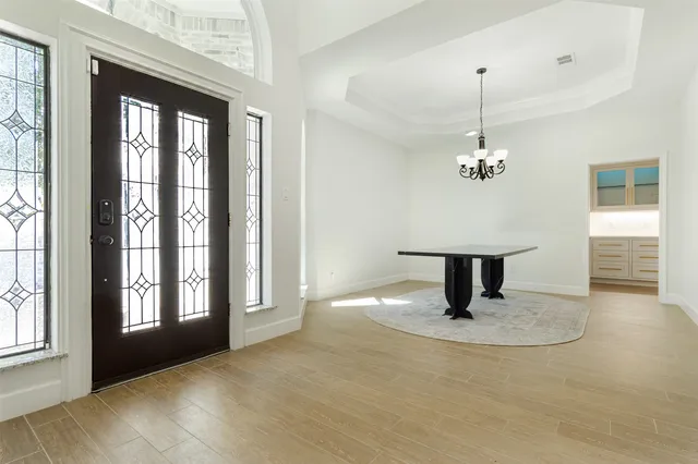 an empty room with windows fireplace and wooden floor