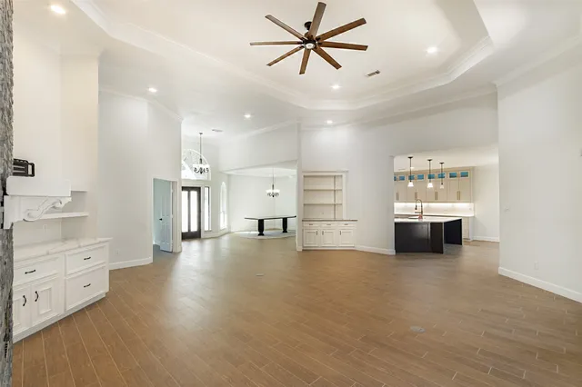 a kitchen with stainless steel appliances granite countertop a sink a refrigerator and a wooden floor