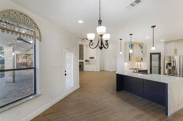 a kitchen with a refrigerator a sink and a wooden floor