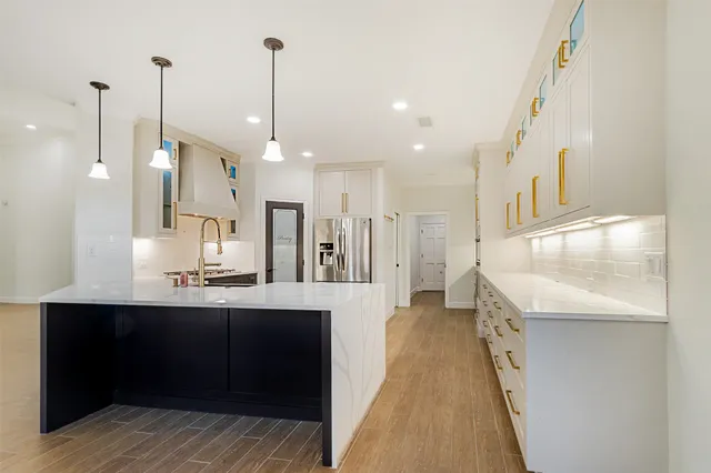 a kitchen with granite countertop a refrigerator and a sink
