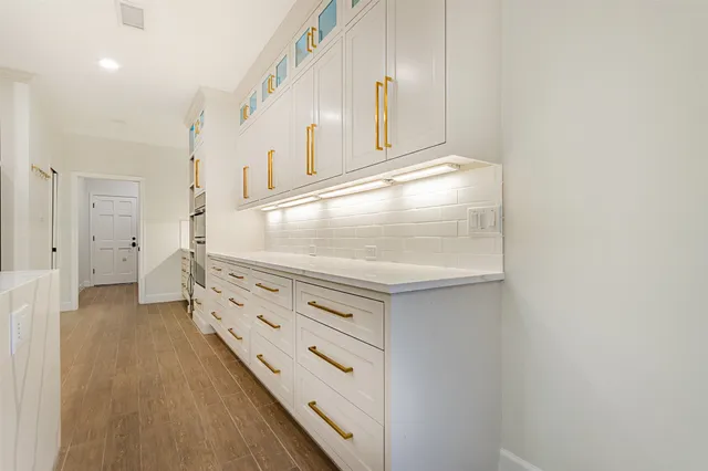 a kitchen with granite countertop white cabinets and a stove