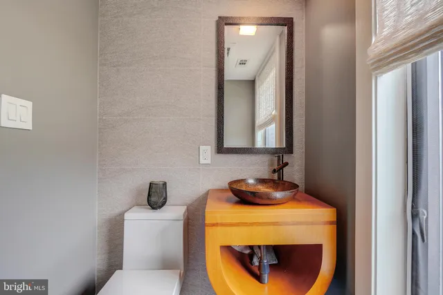 a bathroom with a toilet a sink a window and mirror