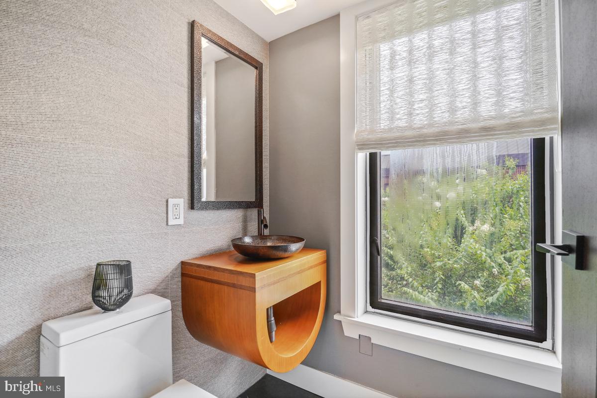 1080 Wisconsin Avenue Northwest, Unit 3002 Washington, DC 20007 - Photo 13 of 38 a bathroom with a toilet a sink a window and mirror