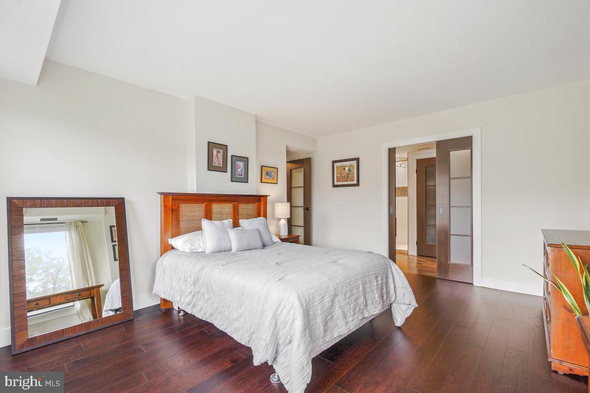 1080 Wisconsin Avenue Northwest, Unit 3002 Washington, DC 20007 - Photo 18 of 38 a bedroom with a bed and wooden floor