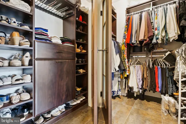 a view of walk in closet with clothes