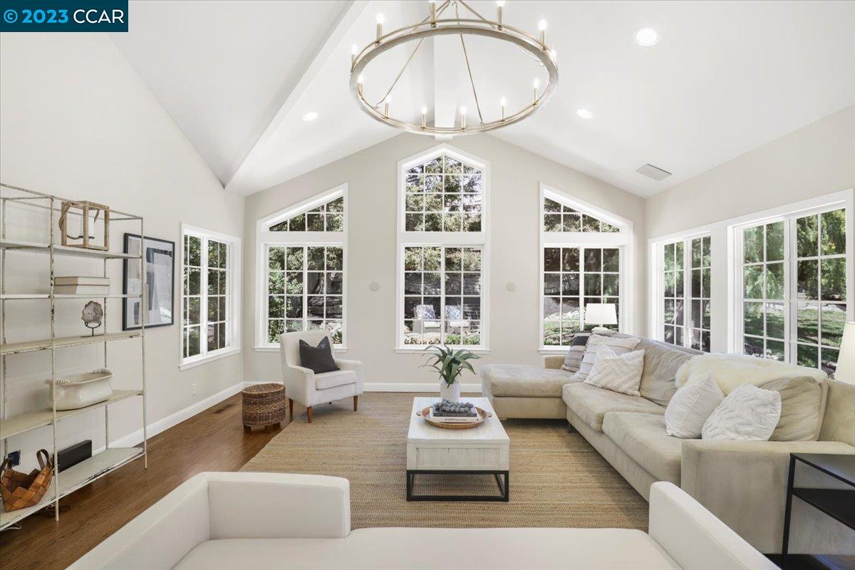 a living room with furniture a chandelier and a large window