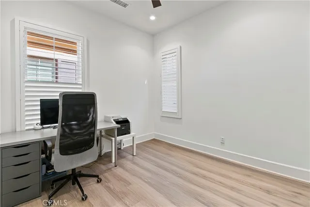 a view of a workspace with furniture and a window