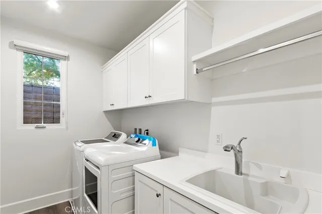 a utility room with sink dryer and washer