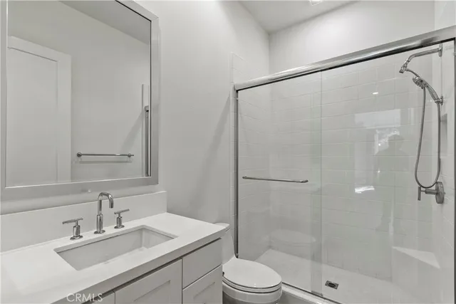 a bathroom with a sink mirror shower and toilet
