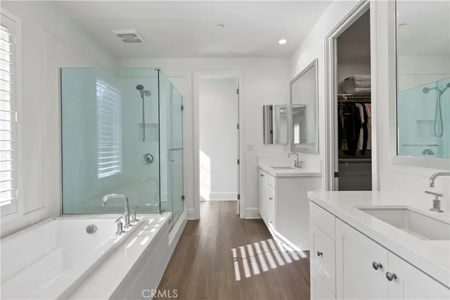 a bathroom with a tub a sink and mirrors