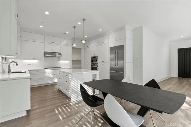 a kitchen with stainless steel appliances granite countertop a sink refrigerator and cabinets