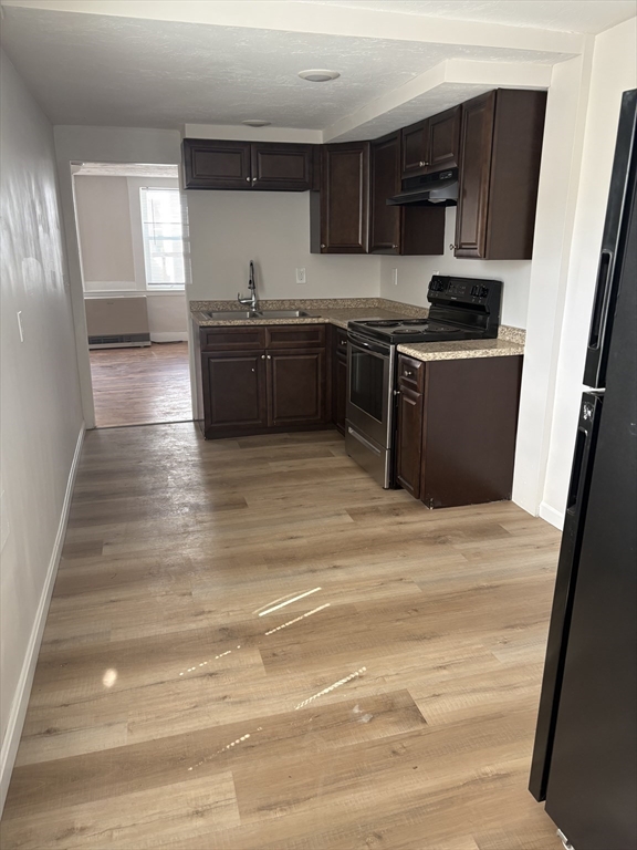 7 Morrill Street, Unit 7 Nashua, NH 03064 - Photo 4 of 15 a kitchen with stainless steel appliances granite countertop a stove a sink and a refrigerator