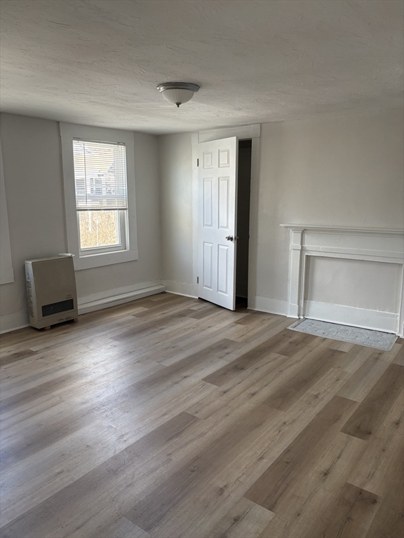 7 Morrill Street, Unit 7 Nashua, NH 03064 - Photo 9 of 15 a view of empty room with wooden floor and fan