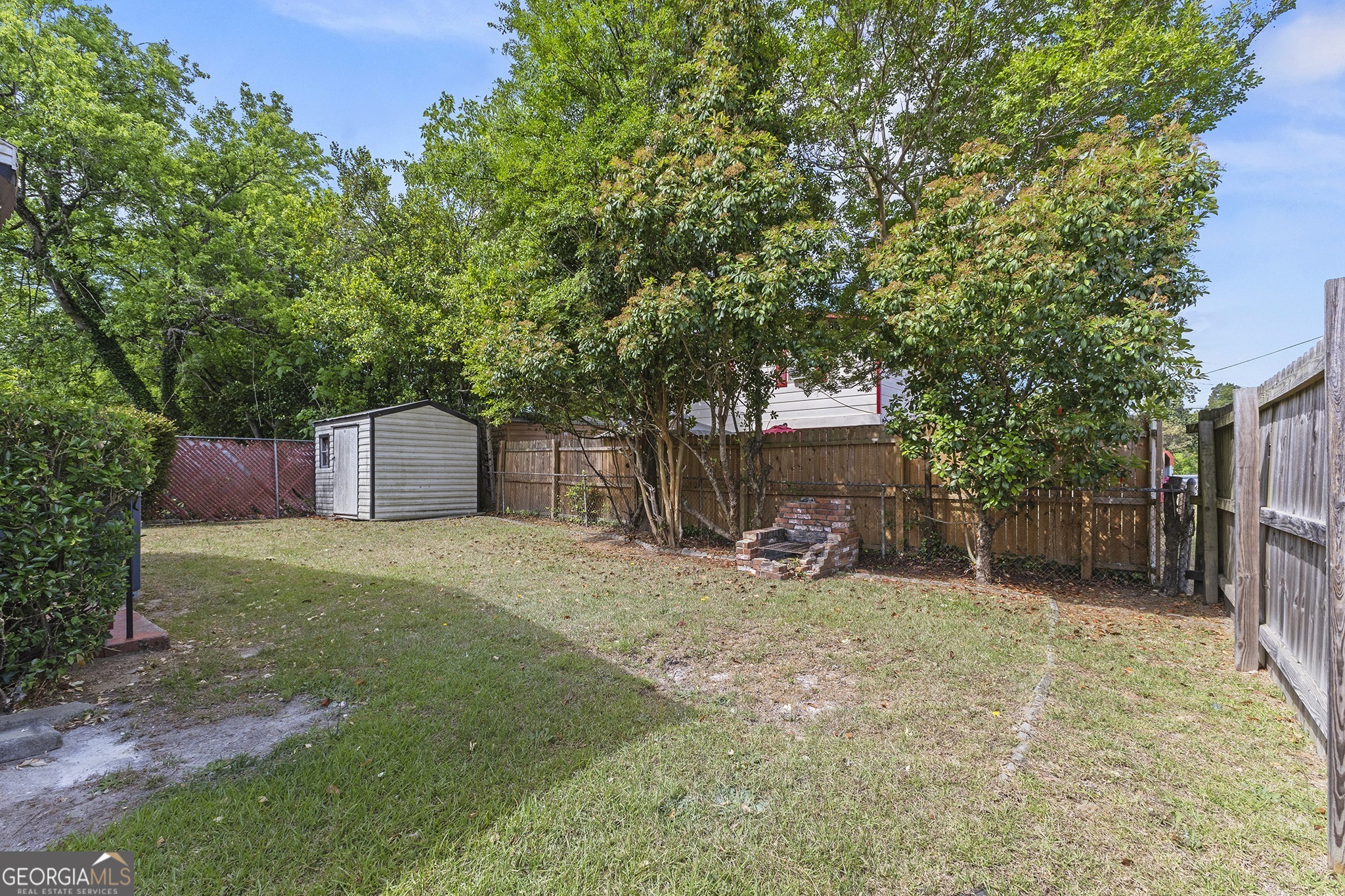 701 Grayson Avenue Macon, GA 31204 - Photo 17 of 17 a backyard of a house with a large tree and wooden fence