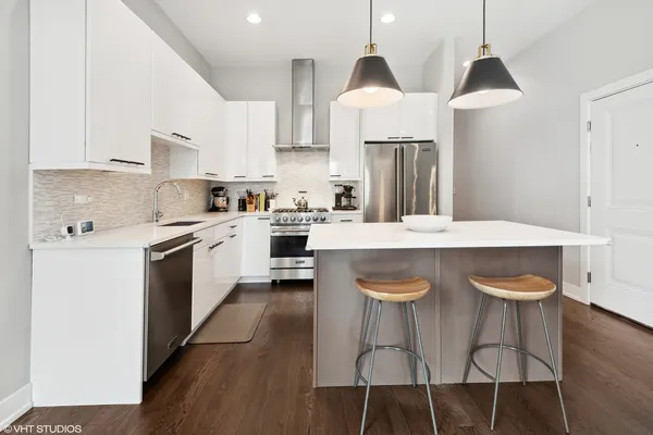 a kitchen with stainless steel appliances granite countertop a sink a stove a refrigerator and island