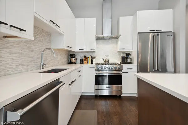 a kitchen with kitchen island a sink stainless steel appliances and cabinets