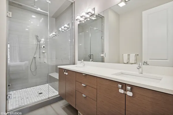 a bathroom with a sink shower and a mirror