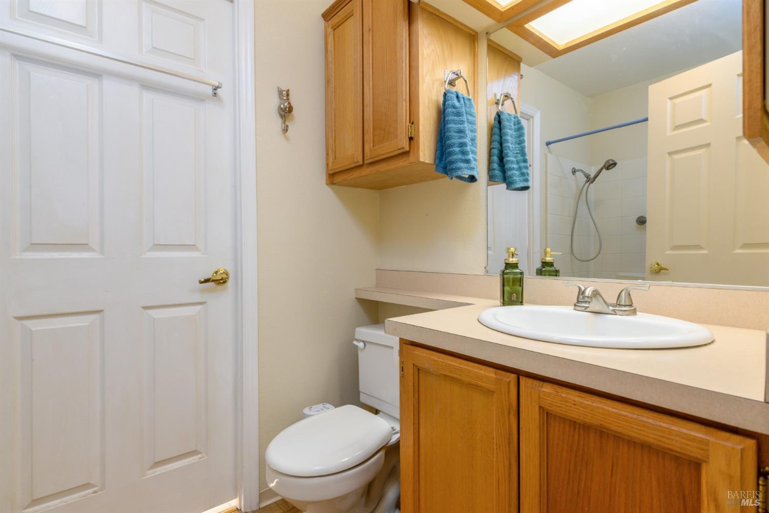 35551 Ocean View Street Gualala, CA 95445 - Photo 21 of 26 a bathroom with a granite countertop sink toilet a mirror and shower