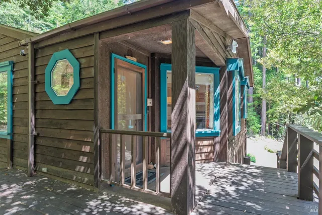 a view of a pathway of a house with a large tree and wooden fence