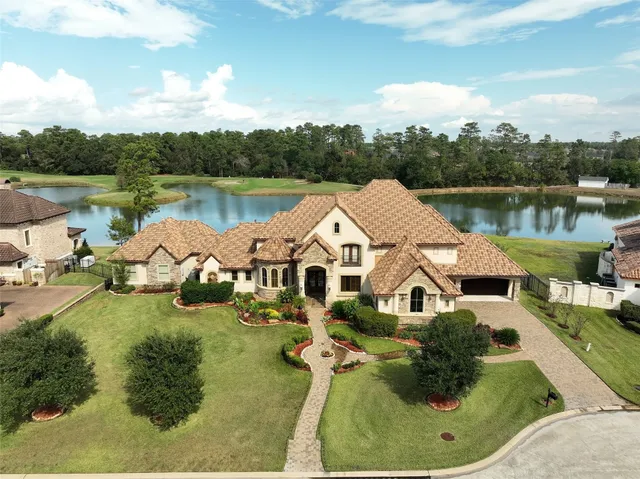 a aerial view of a house with a yard and lake view