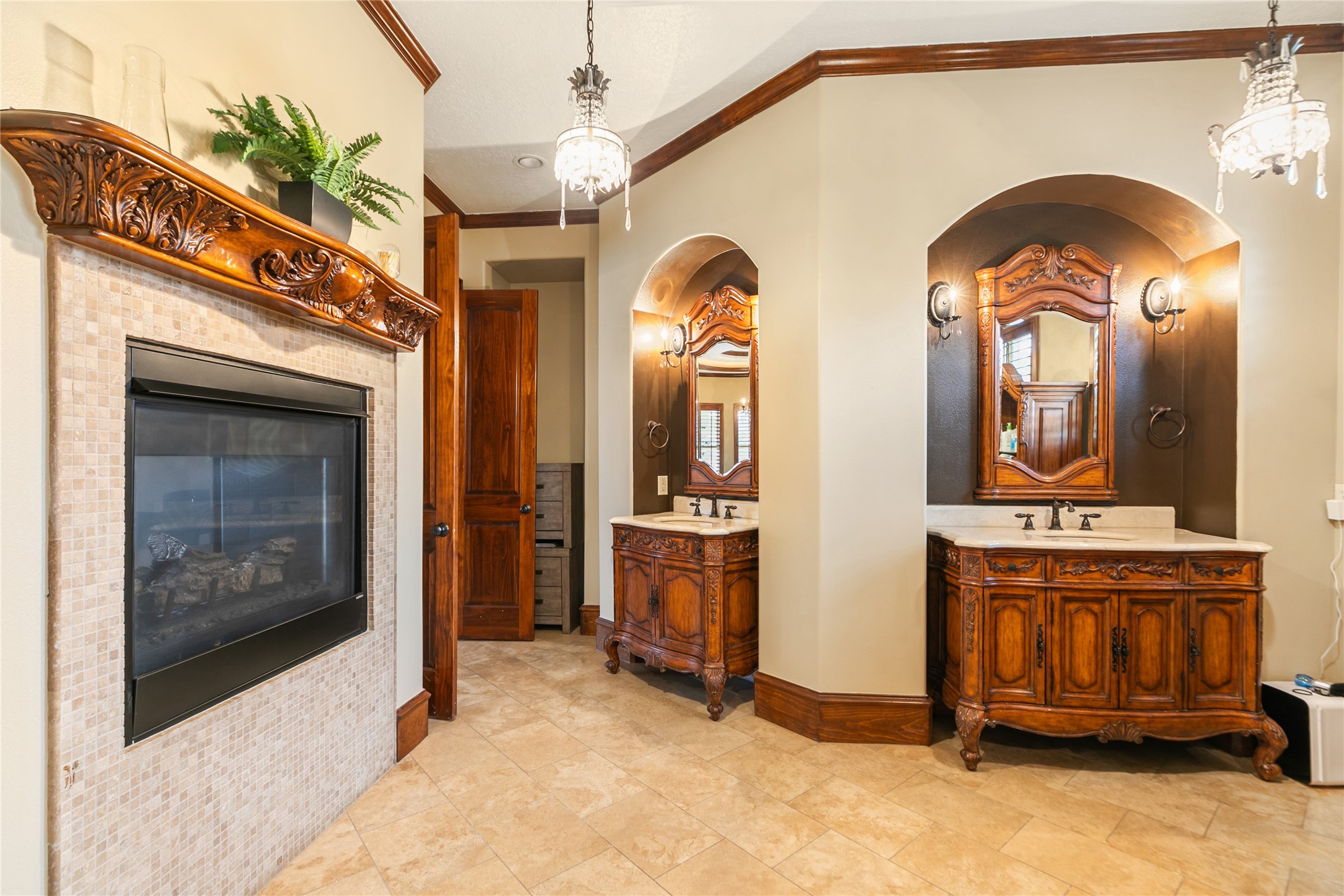 22 Post Shadow Estate Drive Spring, TX 77389 - Photo 35 of 50 The primary bath features rich wood vanities set within attractive alcoves and a dual-sided fireplace, creating a warm and inviting retreat.