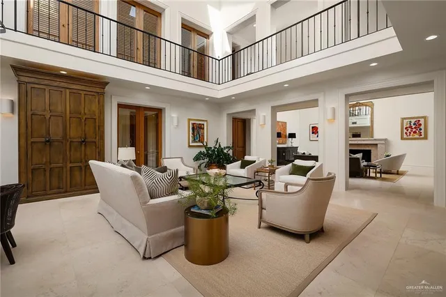 a living room with couches a fireplace and dining table