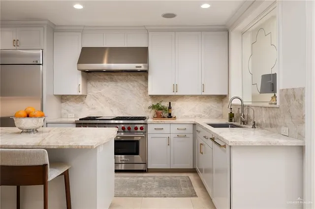 a kitchen with stainless steel appliances granite countertop a sink stove and cabinets