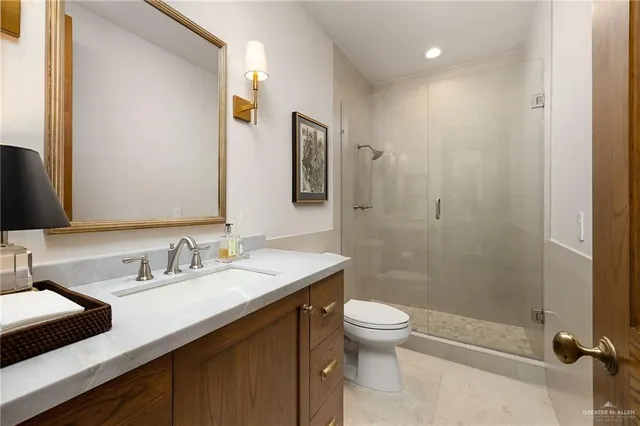 a bathroom with a sink a toilet a shower and a mirror