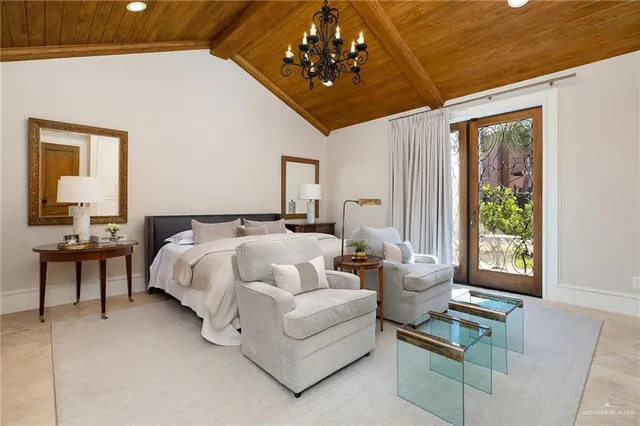 a spacious bedroom with a bed and a chandelier