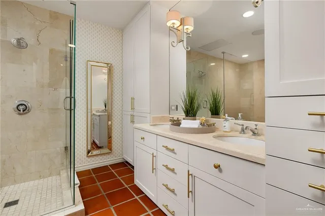 a spacious bathroom with a double vanity sink a mirror and a shower