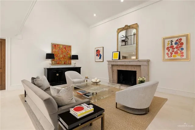 a living room with furniture a fireplace and paintings on the wall