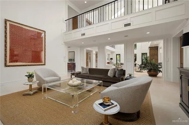 a living room with furniture kitchen view and a large window