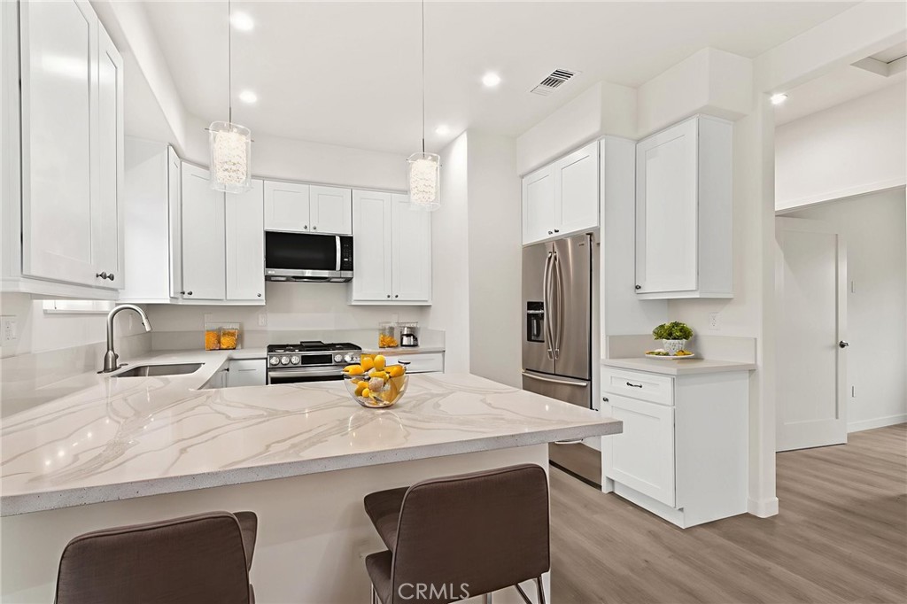 4508 Hedda Street, Unit 2 Lakewood, CA 90712 - Photo 3 of 10 a kitchen with a sink a refrigerator and wooden cabinets