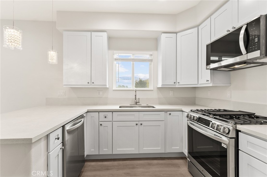4508 Hedda Street, Unit 2 Lakewood, CA 90712 - Photo 4 of 10 a kitchen with white cabinets stainless steel appliances and sink