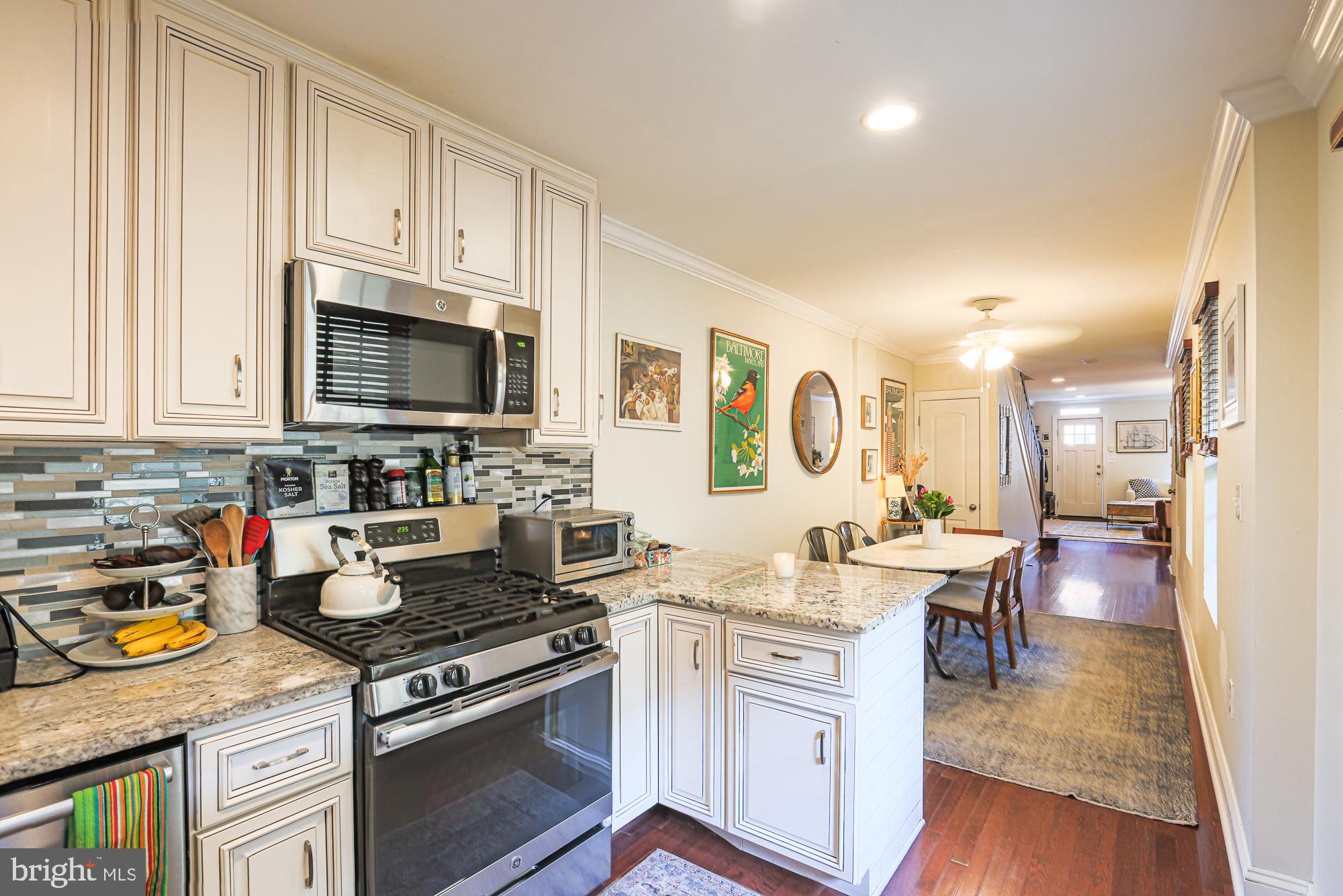 1446 Hull Street Baltimore, MD 21230 - Photo 21 of 54 a kitchen with stainless steel appliances a stove a sink dishwasher a microwave oven with cabinets and wooden floor