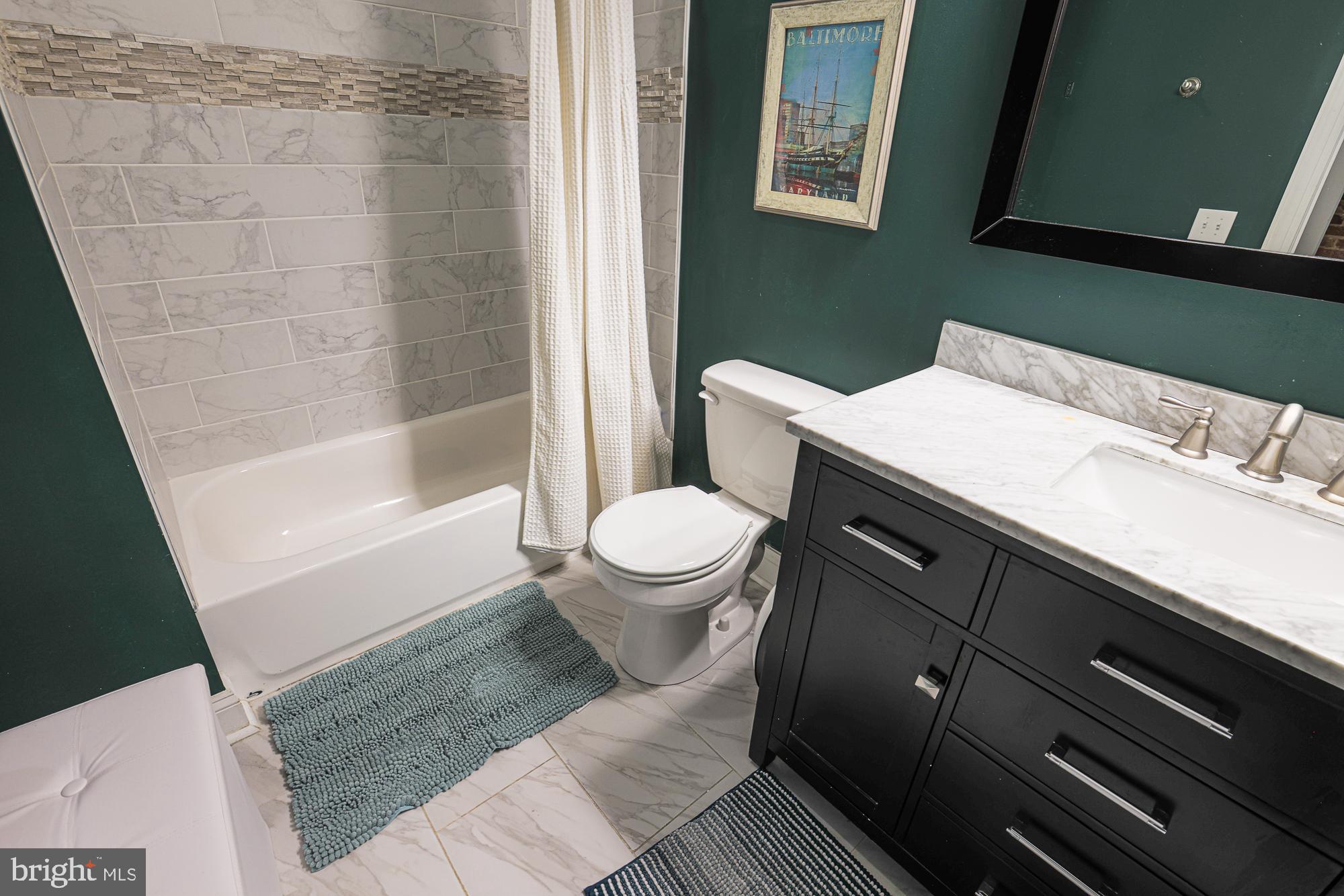 1446 Hull Street Baltimore, MD 21230 - Photo 41 of 54 a bathroom with a sink a toilet a mirror and shower