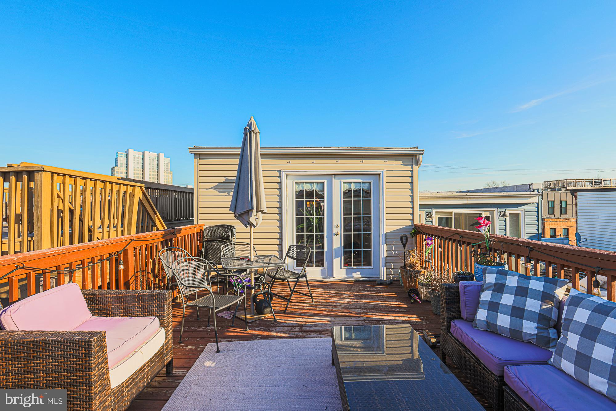 1446 Hull Street Baltimore, MD 21230 - Photo 50 of 54 a view of a deck with couches table and chairs with wooden floor