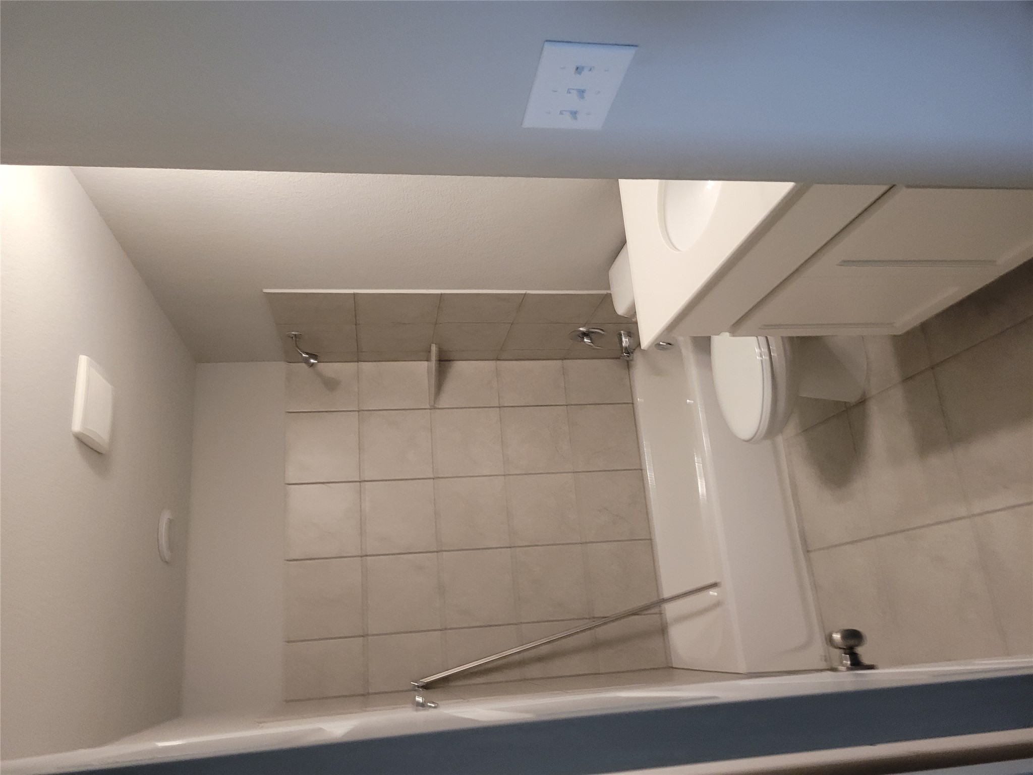 131 Wild Wind Cove Jarrell, TX 76537 - Photo 21 of 26 Bathroom with a white bathtub and shower featuring light-toned tile surround and a built-in shelf