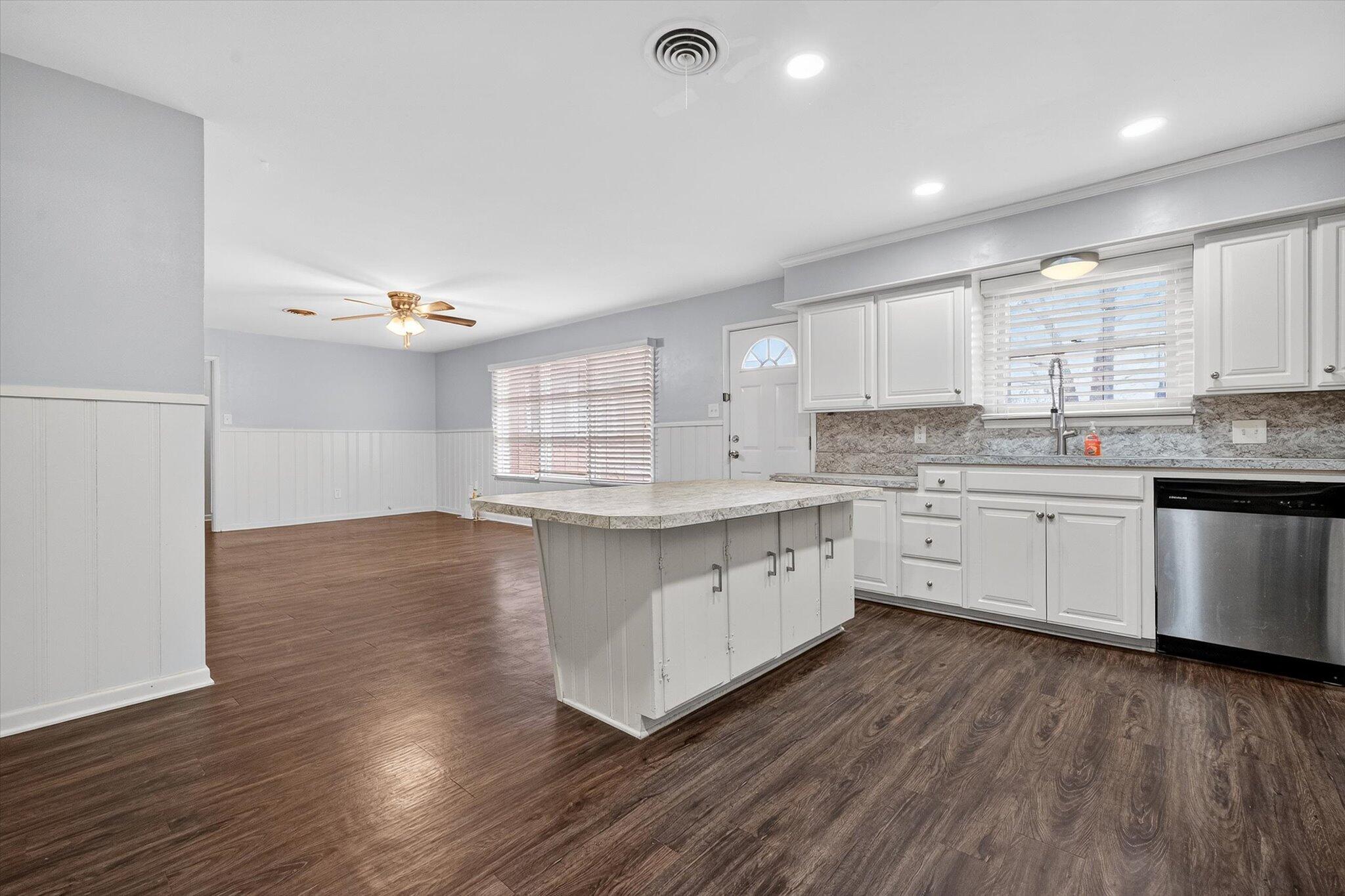 4915 17th Street Lubbock, TX 79416 - Photo 12 of 29 a kitchen with stainless steel appliances cabinets a wooden floor and a sink