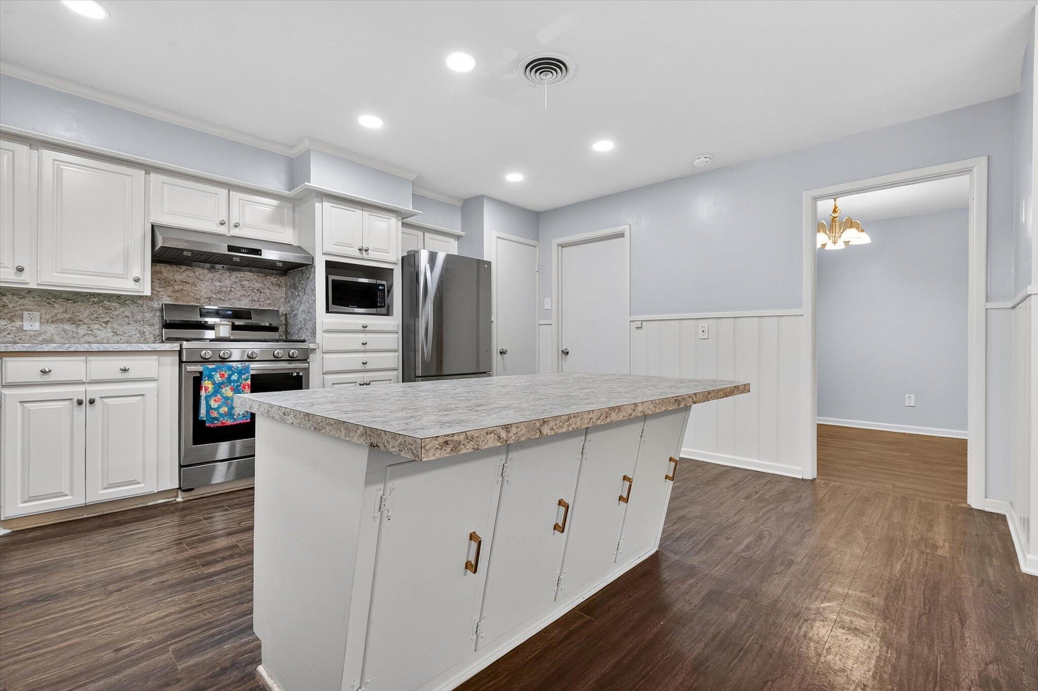 4915 17th Street Lubbock, TX 79416 - Photo 15 of 29 a kitchen with stainless steel appliances kitchen island granite countertop a stove a sink and a refrigerator