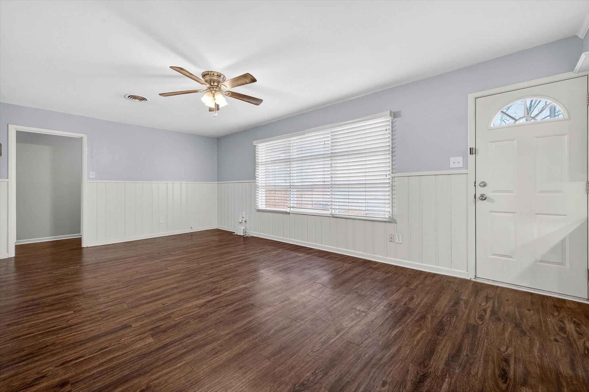 4915 17th Street Lubbock, TX 79416 - Photo 17 of 29 an empty room with wooden floor ceiling fan and windows