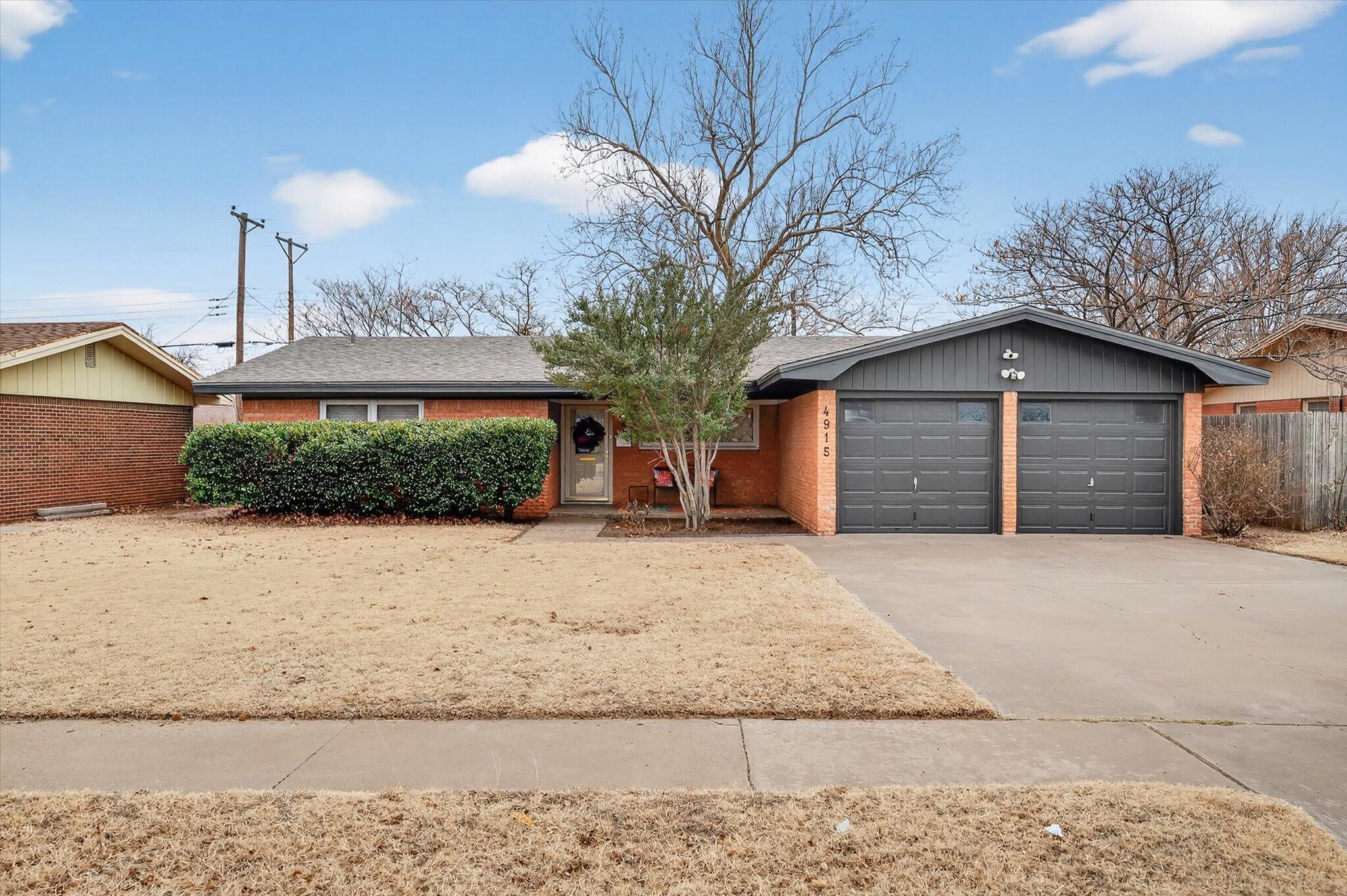 4915 17th Street Lubbock, TX 79416 - Photo 2 of 29 a front view of a house with a yard and garage