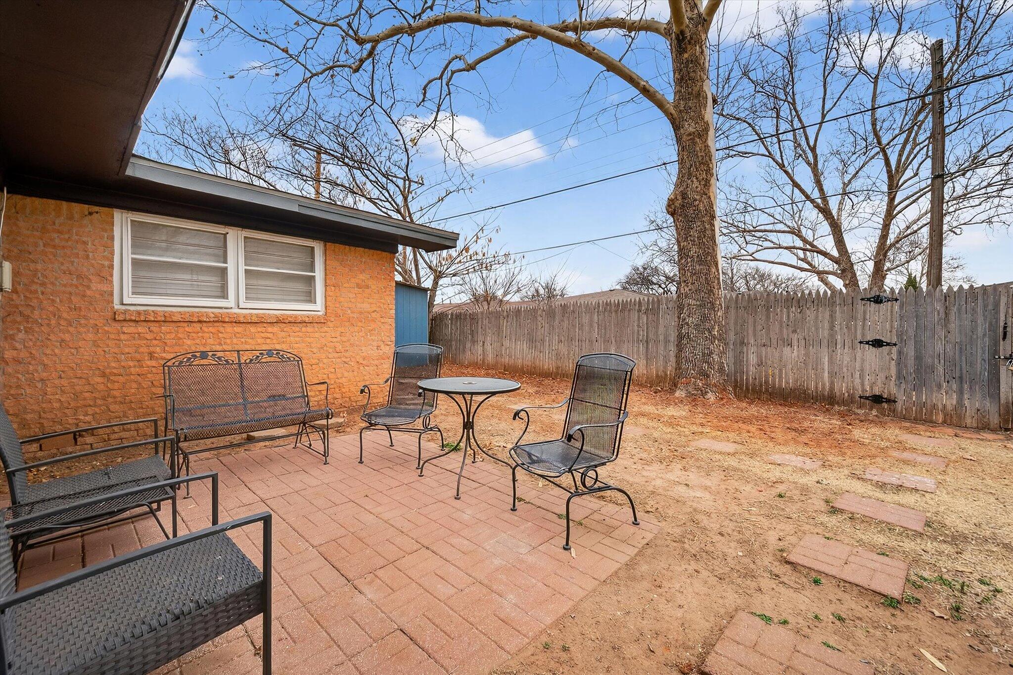 4915 17th Street Lubbock, TX 79416 - Photo 28 of 29 a backyard of a house with table and chairs