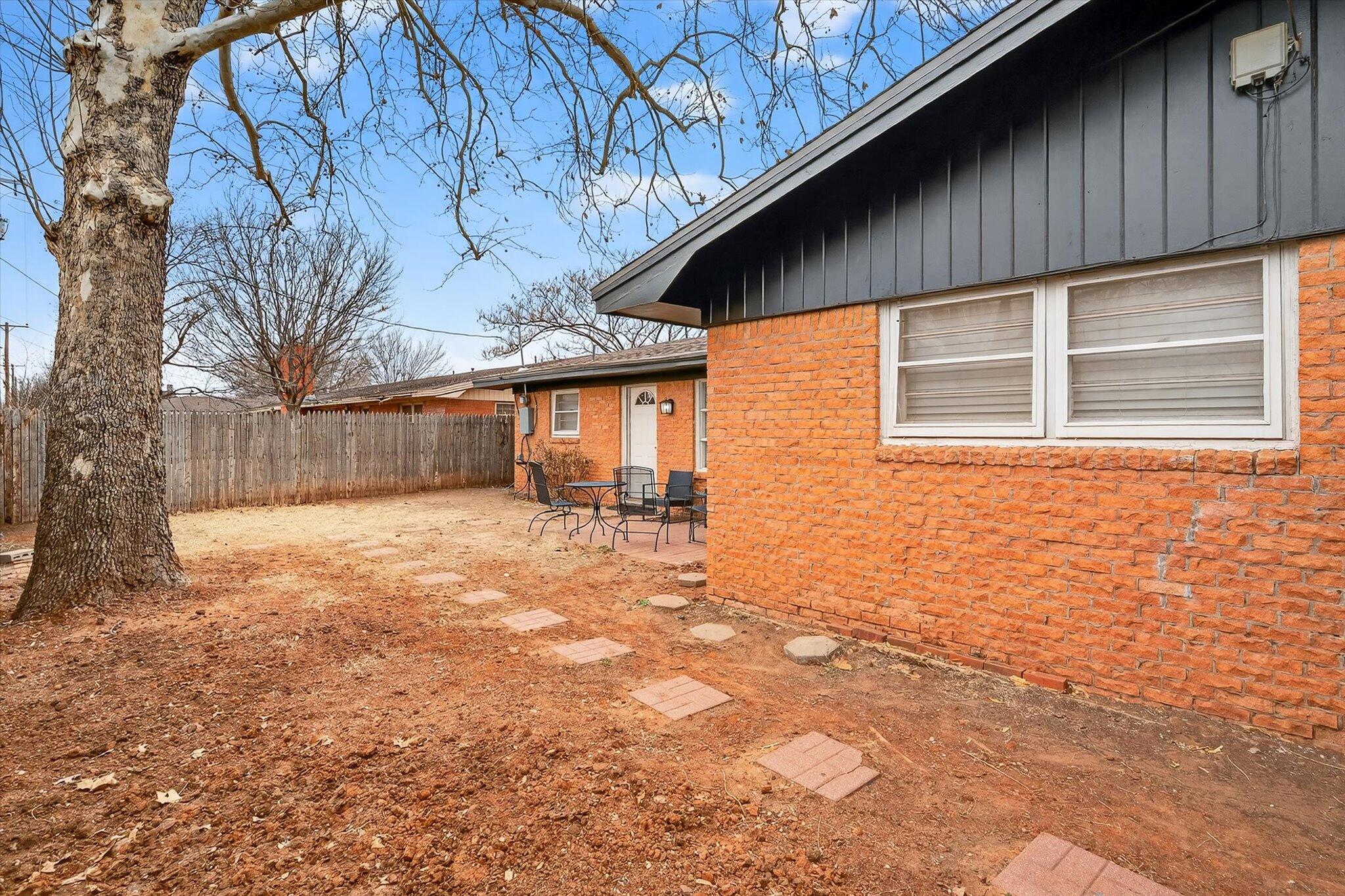 4915 17th Street Lubbock, TX 79416 - Photo 29 of 29 a backyard of a house with large trees and outdoor seating