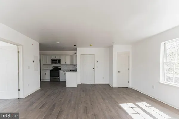 a view of a kitchen with wooden floor and a window