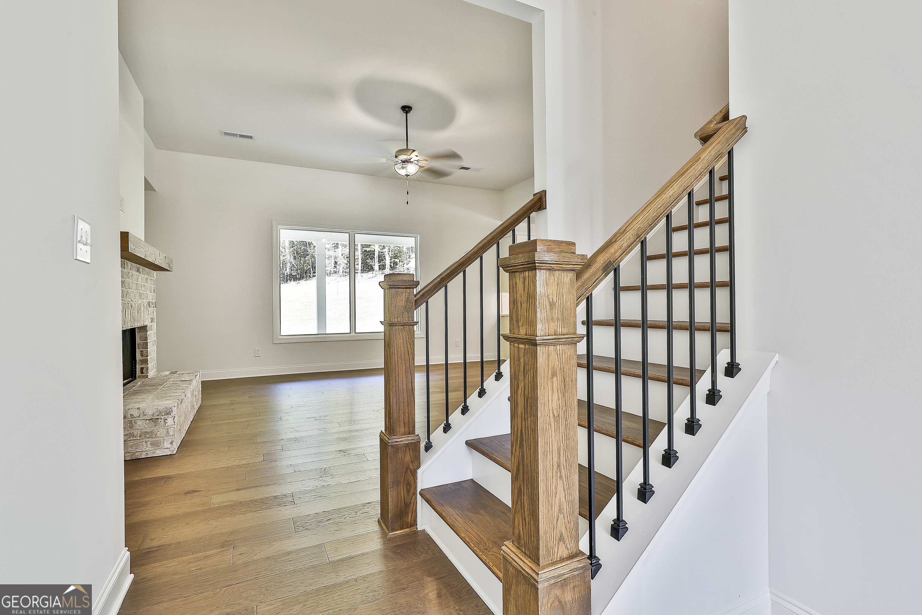 766 Wisteria Lane, Unit 55 Williamson, GA 30292 - Photo 12 of 52 a view of staircase with wooden floor and fan