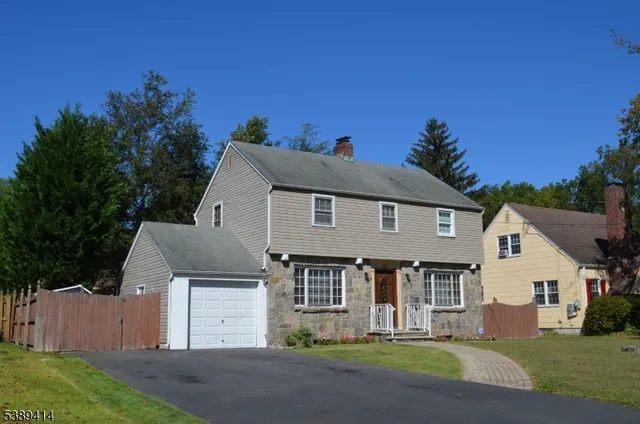 a front view of a house with a garden and yard