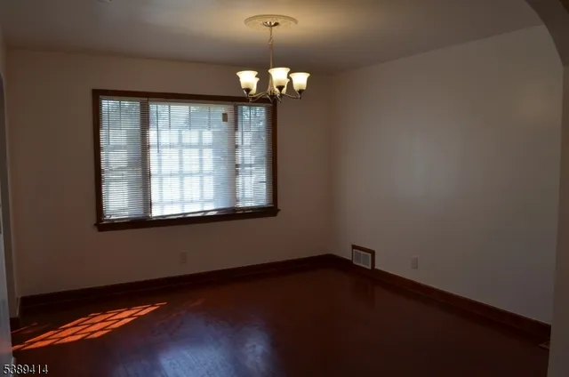 a view of wooden floor and a chandelier in a room