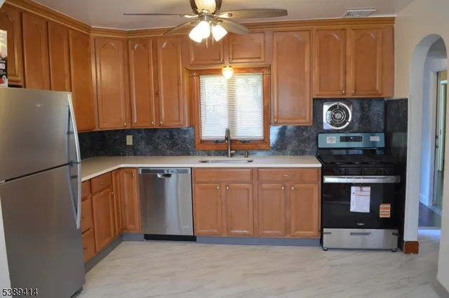 a kitchen with stainless steel appliances granite countertop a refrigerator a stove a sink and dishwasher
